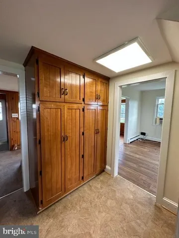 an empty room with wooden floor fireplace and windows