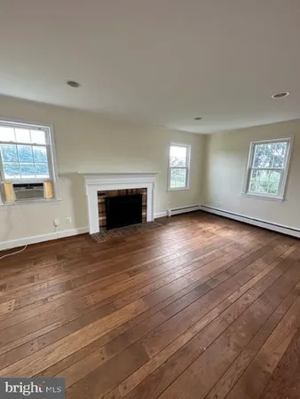 a view of a livingroom with wooden floor and a large window