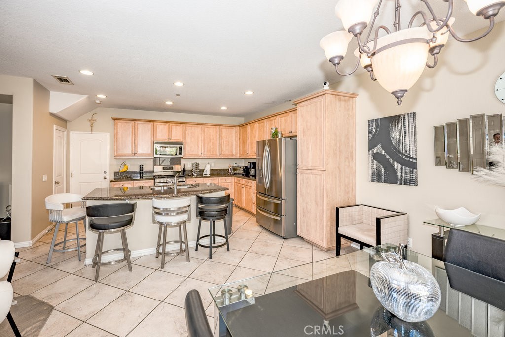 3631 Dunkirk Drive Oxnard, CA 93035 - Photo 7 of 16 a kitchen with stainless steel appliances kitchen island granite countertop a sink a stove a dining table and chairs