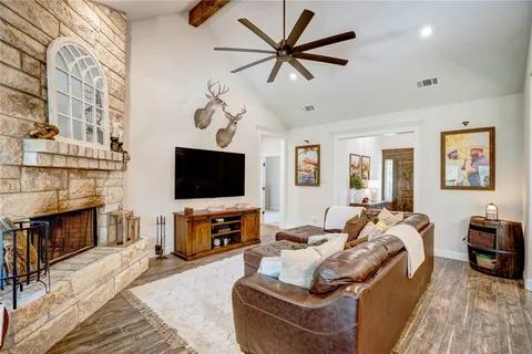 a living room with furniture a flat screen tv and a fireplace