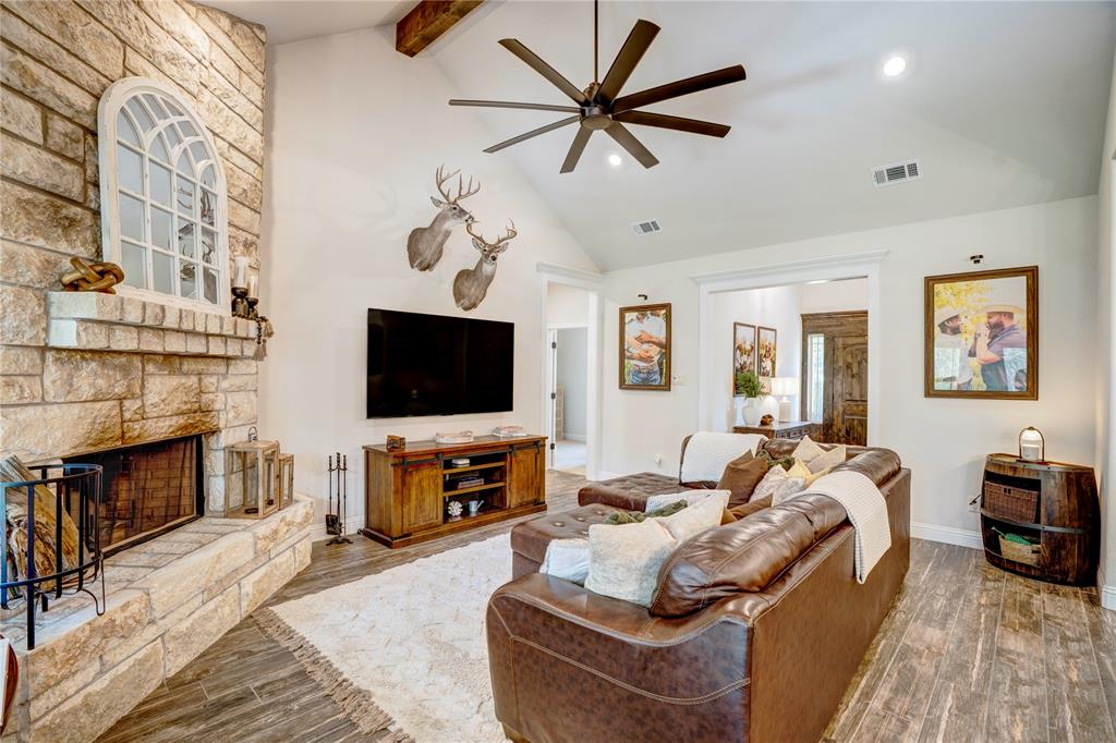 1355 Jay Bird Road Springtown, TX 76082 - Photo 14 of 40 a living room with furniture a flat screen tv and a fireplace