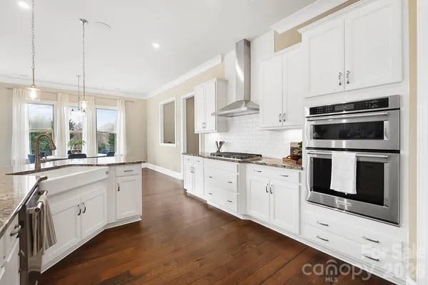 a large white kitchen with stainless steel appliances