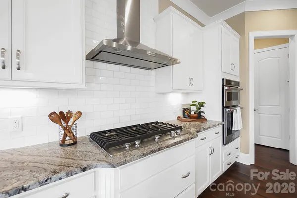 a kitchen with stainless steel appliances granite countertop a sink stove and cabinets
