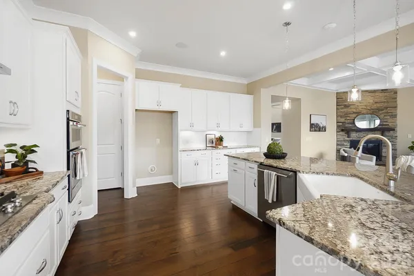 a large kitchen with stainless steel appliances granite countertop a lot of counter space and wooden floor