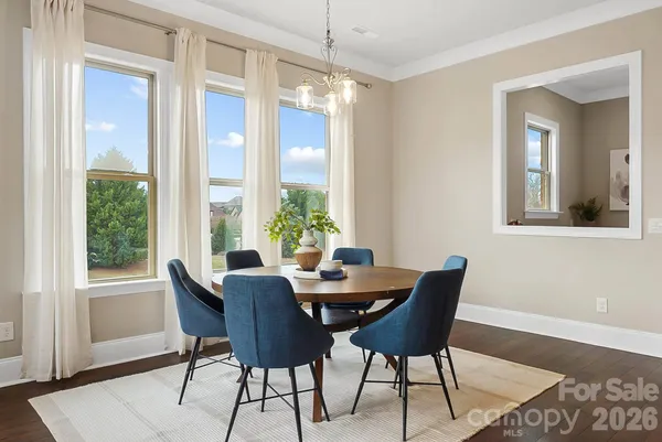 a dining room with furniture a chandelier and wooden floor