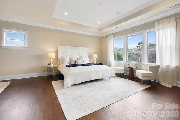 a bedroom with a bed couch and a large window