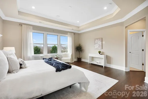 a large bedroom with a bed and wooden floor