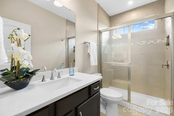 a bathroom with a sink a toilet and shower