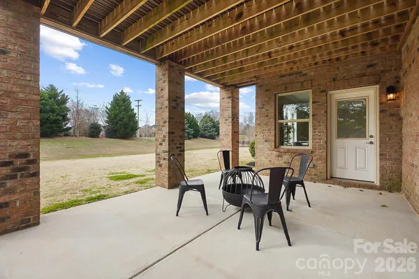 a view of a patio with table and chairs and floor to ceiling window with wooden floor