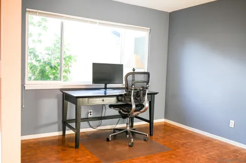 a view of a workspace with furniture and a window