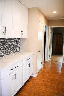a kitchen with granite countertop white cabinets and refrigerator
