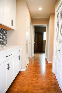 a view of a refrigerator in kitchen and an empty room