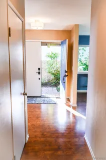 a view of empty room with wooden floor and floor to ceiling window