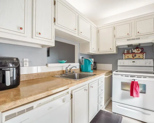 a kitchen with white cabinets and white appliances