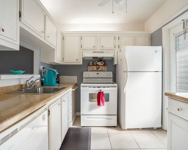 a kitchen with refrigerator and cabinets
