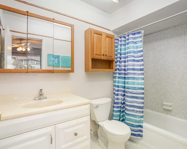 a bathroom with a sink a toilet a mirror and a shower