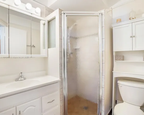 a bathroom with a shower a sink and a toilet