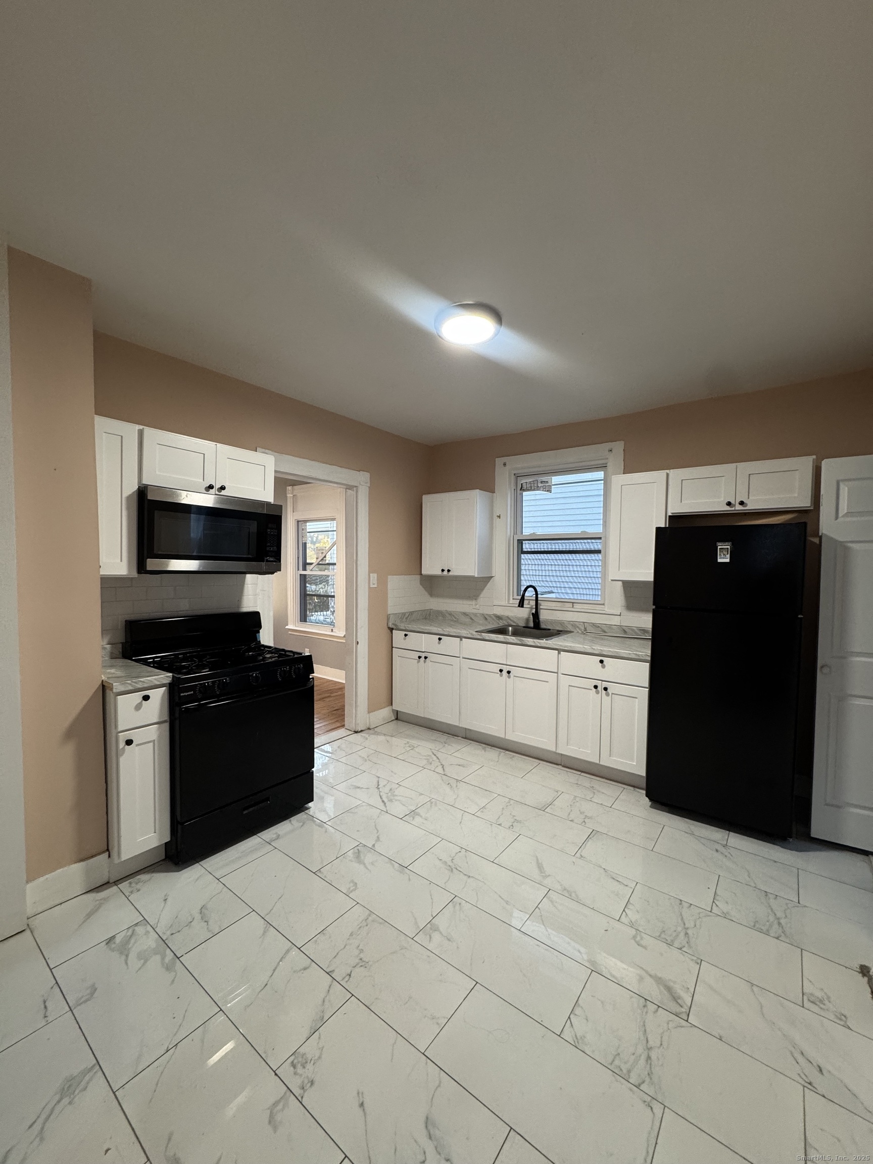 a kitchen with stainless steel appliances granite countertop a refrigerator and a stove top oven