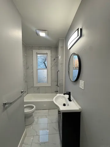a bathroom with a sink mirror toilet and a bathtub