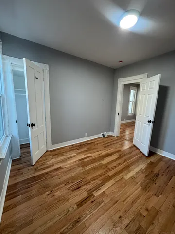 a view of empty room with wooden floor