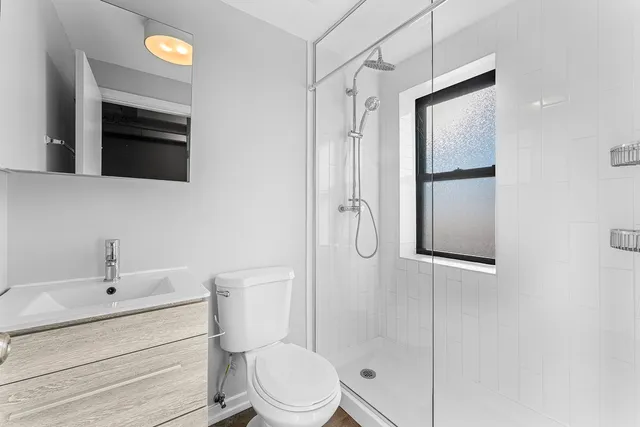 a bathroom with a sink a toilet and shower