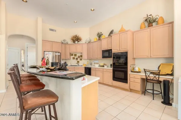 a kitchen with cabinets a sink and chairs