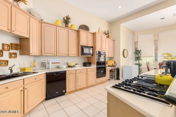a kitchen with stainless steel appliances granite countertop a stove a sink dishwasher and cabinets with wooden floor