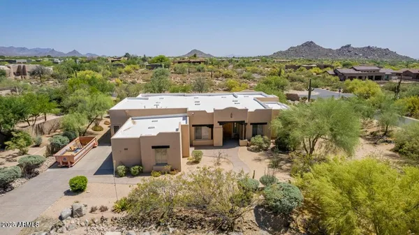 an aerial view of a house with a mountain