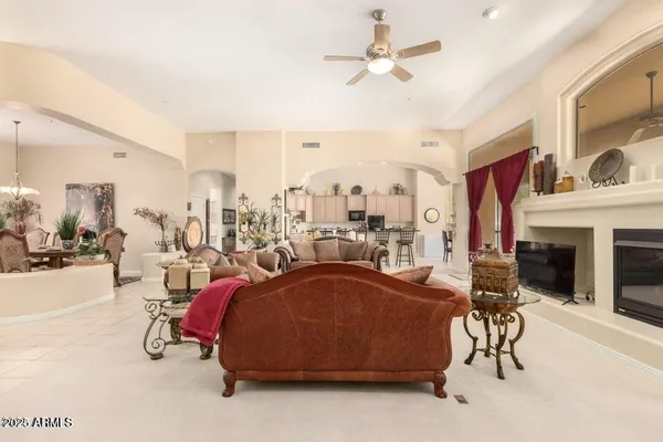 a living room with furniture a fireplace and a chandelier