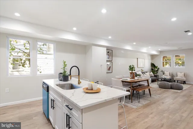 a kitchen with a sink dishwasher a dining table and chairs with a large window
