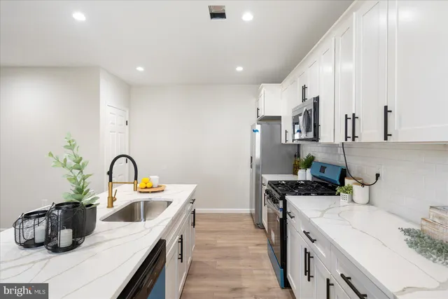 a kitchen with a sink a stove and cabinets