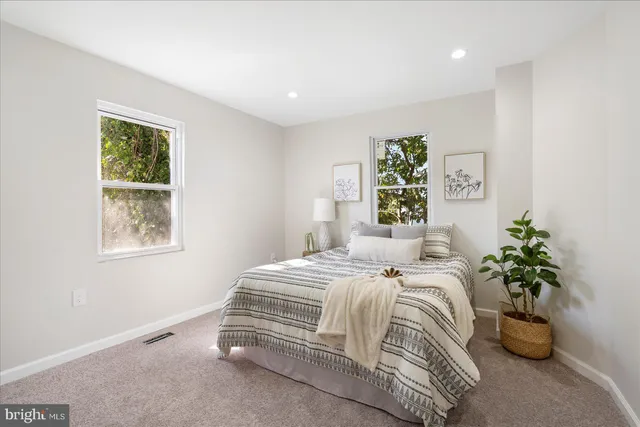 a bedroom with a bed and a potted plant