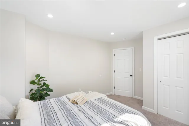 a bedroom with a bed and a potted plant