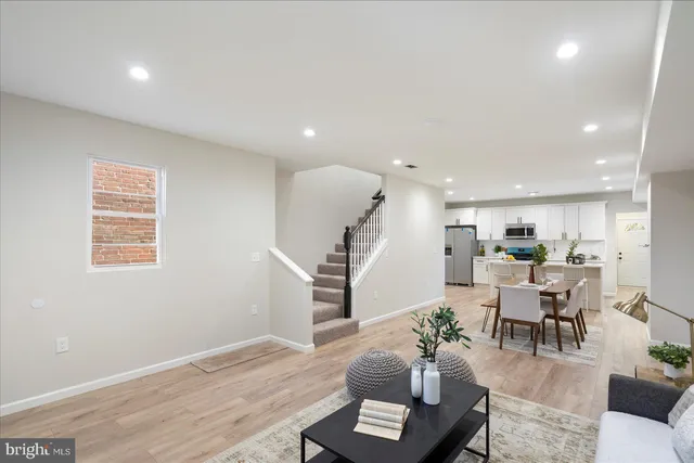 a living room with furniture kitchen and a wooden floor