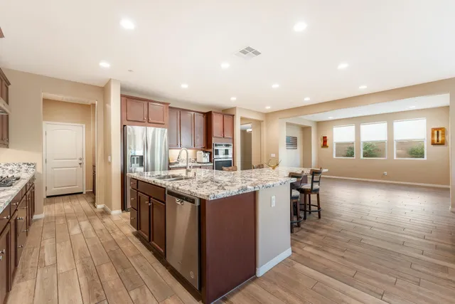 a kitchen with granite countertop a stove and a wooden floor