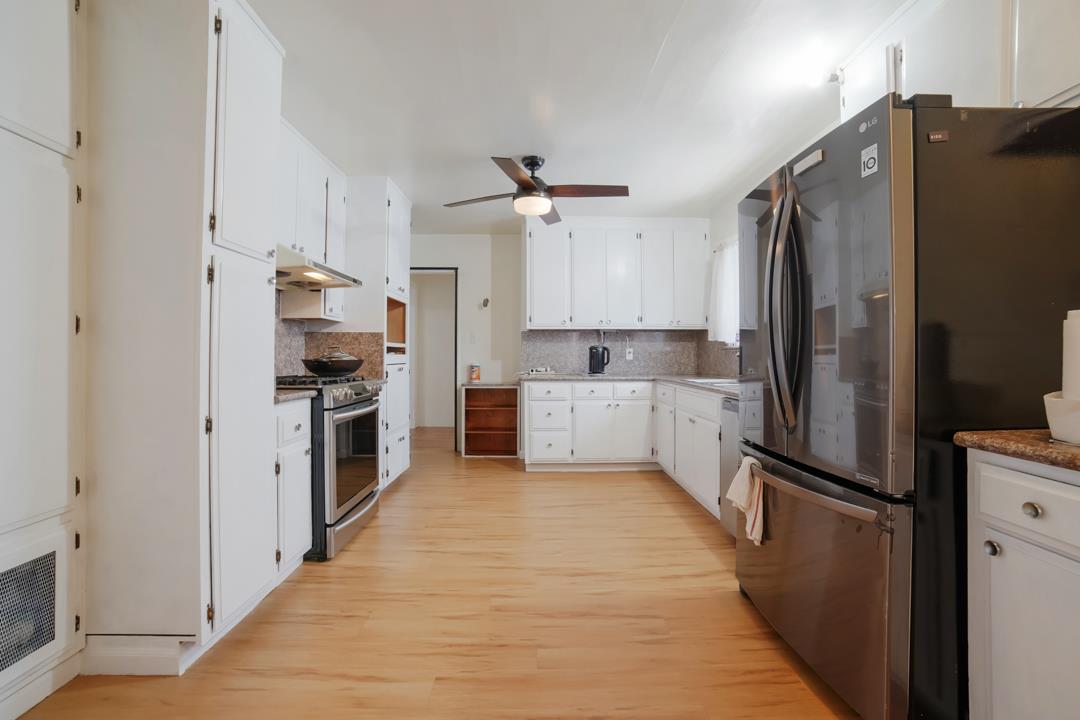 2276 35th Avenue Oakland, CA 94601 - Photo 19 of 32 a kitchen with stainless steel appliances a refrigerator sink and cabinets