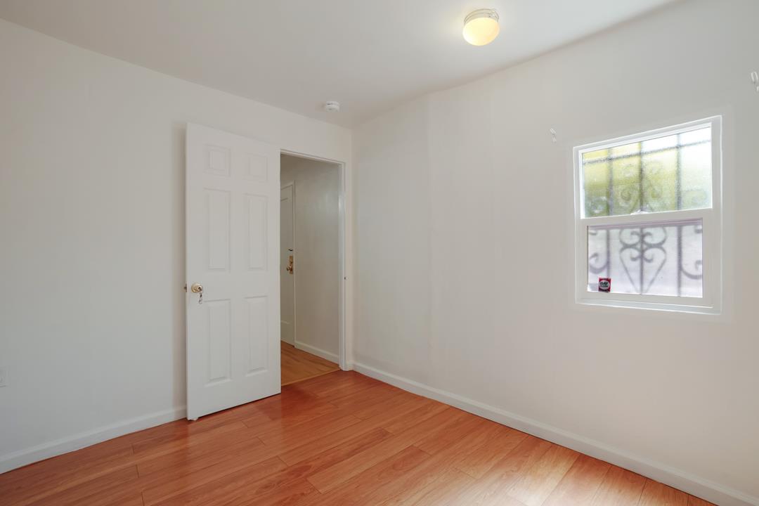 2276 35th Avenue Oakland, CA 94601 - Photo 23 of 32 an empty room with wooden floor and windows