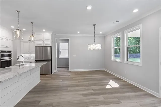 a view of kitchen with kitchen island stainless steel appliances wooden floor and window