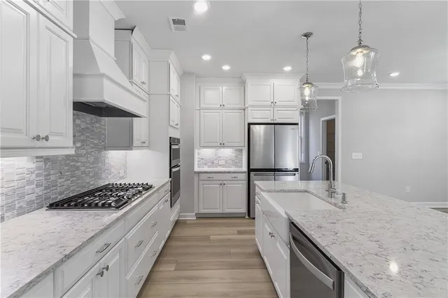 a kitchen with a sink stainless steel appliances a refrigerator and a stove