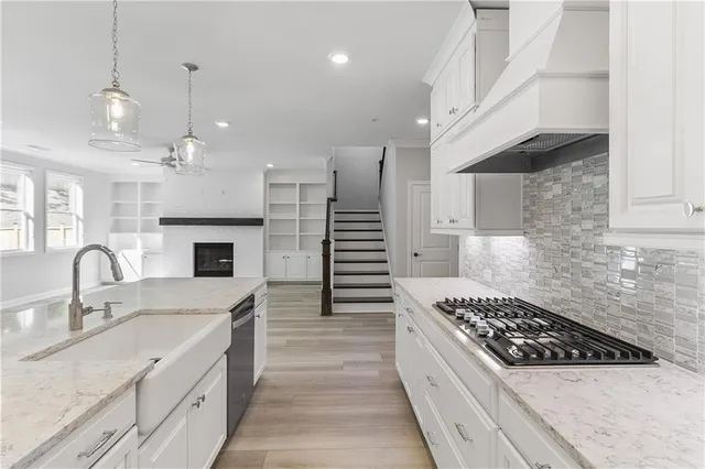 a kitchen with granite countertop a sink stove and cabinets