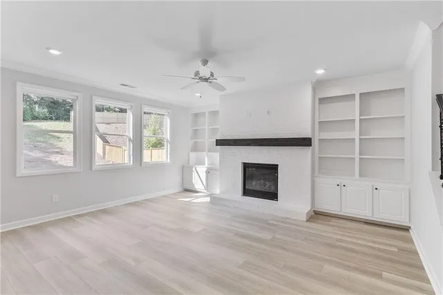 wooden floor fireplace and windows in an empty room