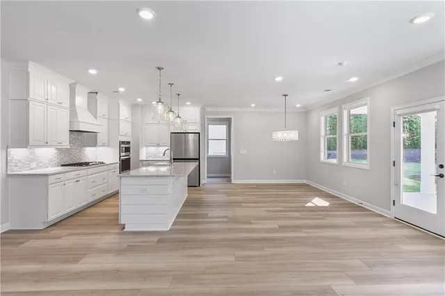 a large kitchen with kitchen island a sink stainless steel appliances and cabinets