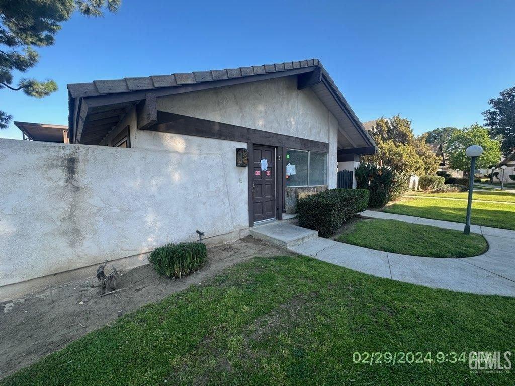 Undisclosed Address Bakersfield, CA 93301 - Photo 2 of 8 a front view of a house with a yard
