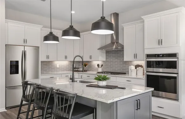 a kitchen with stainless steel appliances granite countertop a sink a stove and a refrigerator