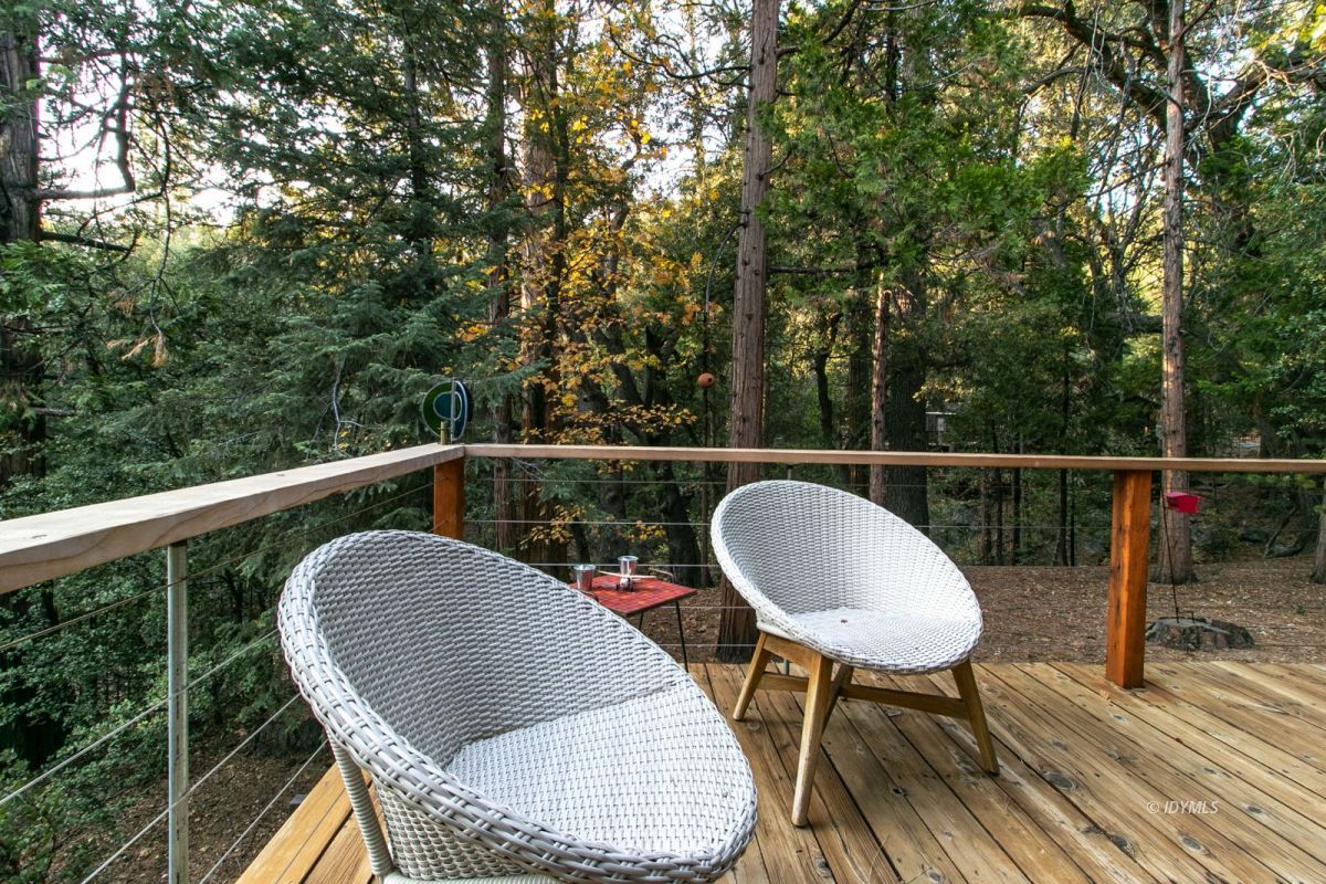 25325 Fern Valley Road Idyllwild, CA 92549 - Photo 34 of 54 a balcony with wooden floor table and chairs