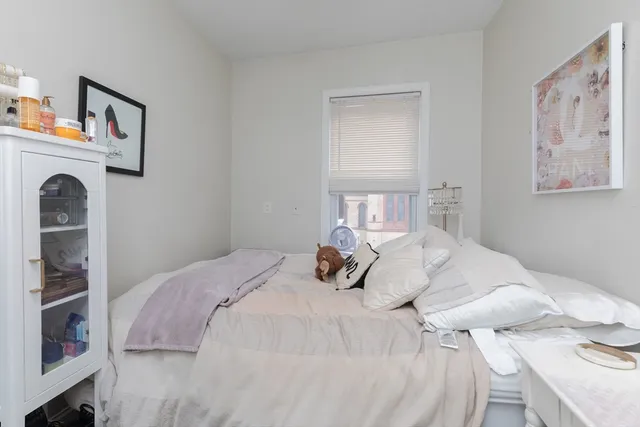 a bedroom with a bed and painting on the wall