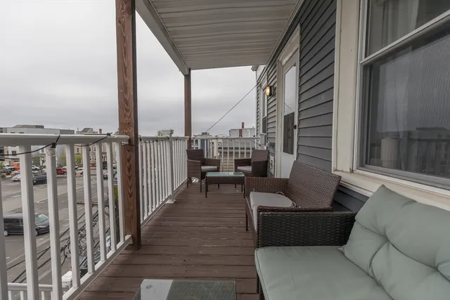 a roof deck with couches and potted plants