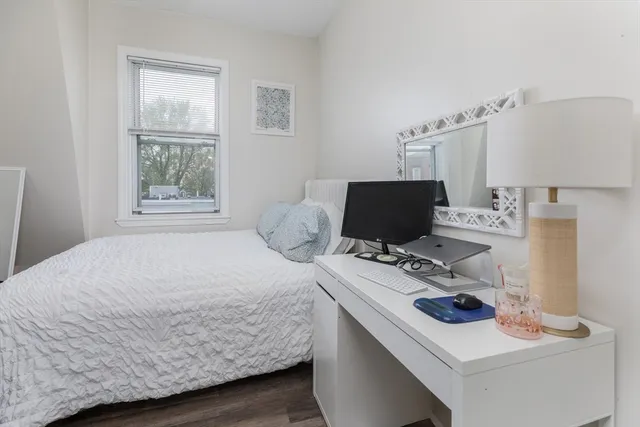 a bedroom with a bed and a computer on a desk