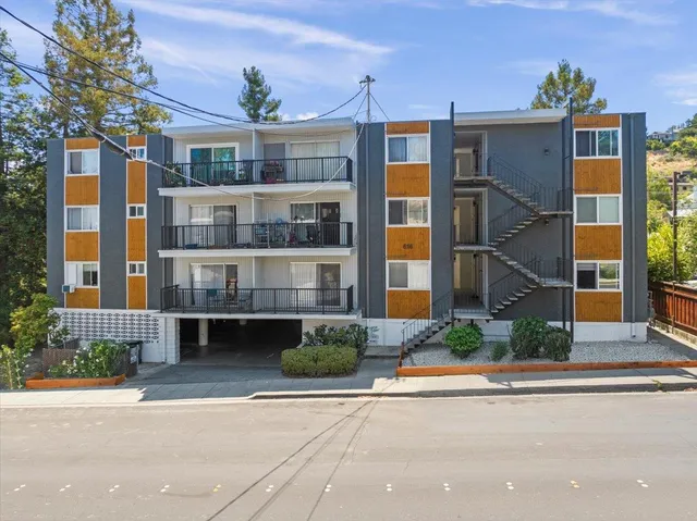 a front view of a house with a yard and potted plants