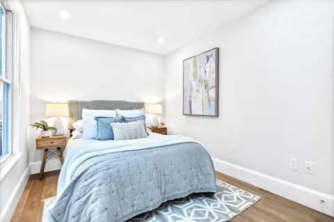 a bedroom with a bed and wooden floor